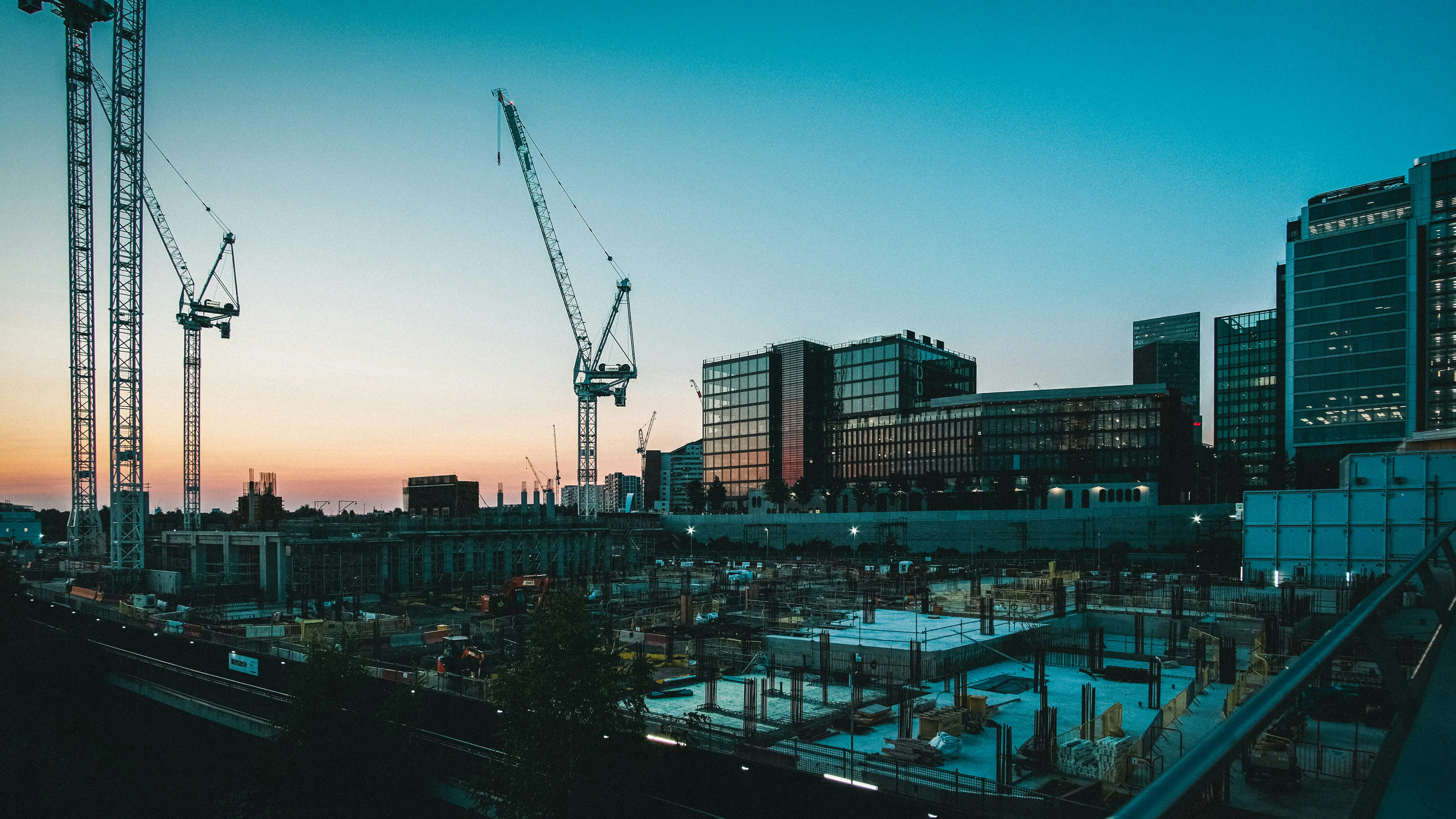 Chantier urbain au crépuscule, grues et immeubles en construction